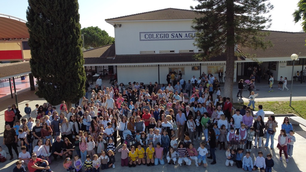 Más de doscientas familias del Colegio, con sus hijas e hijos, posando juntas en el patio delante del edificio con el rótulo de azulejos «Colegio San Agustín», vistas desde lo alto