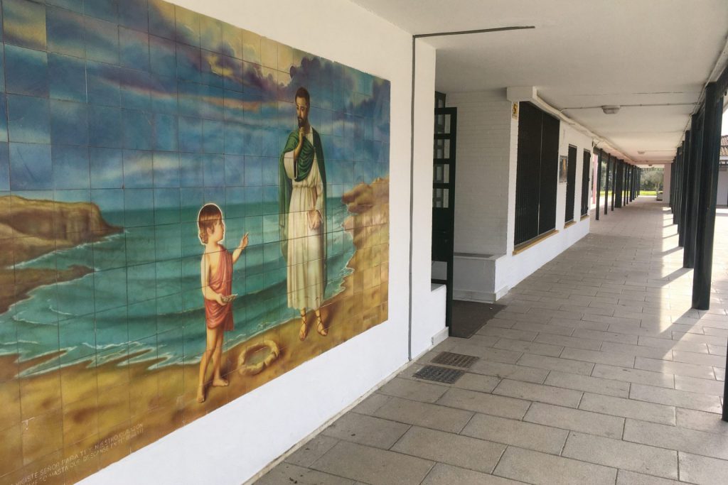 Mural de cerámica con una escena marina: un niño y una figura junto a la orilla