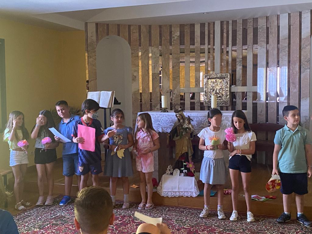 Alumnos de pie con sus hojas de lectura durante una celebración